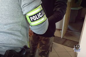 POLICJACI prowadza zatrzymanych