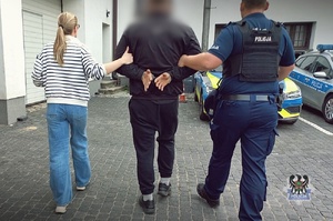 POLICJACI prowadza zatrzymanych