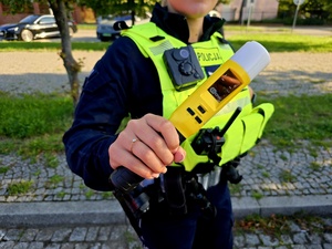 policjant z miernikiem alkoholu w rekach