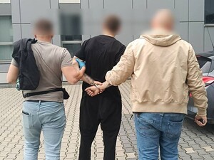 policjanci prowadzą zatrzymanego