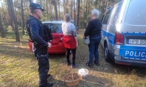 policjant z odnalezioną kobietą w lesie