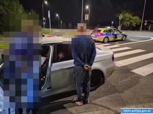 mężczyźni stojący obok samochodu osobowego przed nimi radiowóz