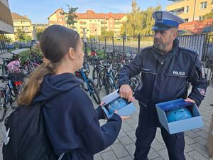 policjant rozdaje kaski