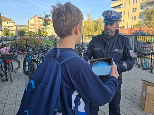policjant rozdaje kaski