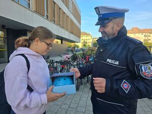 policjant rozdaje kaski