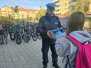 policjant rozdaje kaski