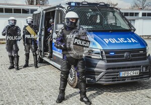 policjanci koło busa policyjnego