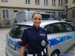 Na zdjęciu policjantka stojąca przed radiowozem.