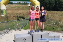 Trzy kobiety stojące na podium z medalami
