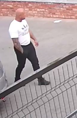 Na zdjęciu kolejny mężczyzna  podejrzewany o popełnienie przestępstwa ubrany w białą koszulkę i czarne długie spodnie.