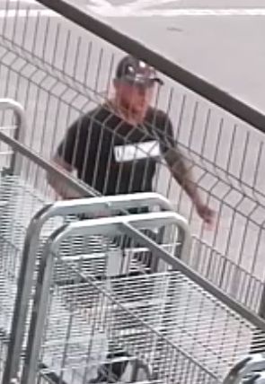 Na zdjęciu kolejny mężczyzna  podejrzewany o popełnienie przestępstwa ubrany w czarną koszulkę z białym napisem i czarną czapeczkę.