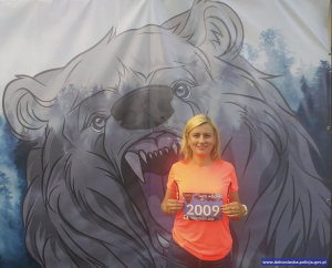 komisarz Beata Borowicz w tle logo maratonu - głowa niedźwiedzia
