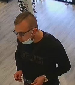 Profil poszukiwanego mężczyzny w maseczce ochronnej złożonej na brodzie, w okularach i ciemnej bluzie