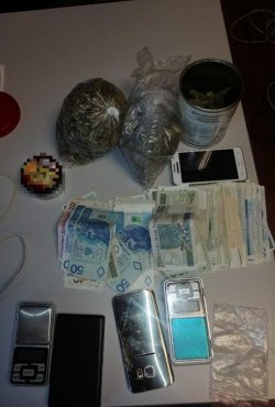 Marihuana w woreczkach i pojemnikach, banknoty, telefony komórkowe  zabezpieczone przez policjantów