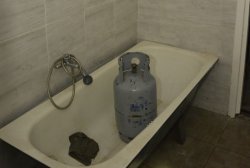 Butla gazowa stojąca w wannie w łazience