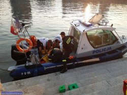 Łódka policyjna na której znajduje się uratowana kobieta i policjanci z komisariatu wodnego