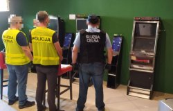 Policjant oraz dwóch celników zabezpieczają nielegalne automaty do gier