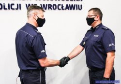 Komendant Wojewódzki Policji we Wrocławiu inspektor Dariusz Wesołowski składa gratulacje nadkom. Rafałowi Rasz