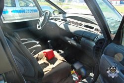 Wnętrze samochodu od strony pasażera, a za oknem widoczny radiowóz.