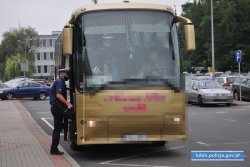 Dwaj policjanci podczas kontroli autobusu pracowniczego. Policjanci wchodzą do autobusu i przeprowadzają kontrolę przestrzegania reżimu sanitarnego i nakazu zakrywania ust i nosa w autobusach.