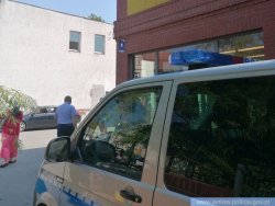 Radiowóz policyjny przy placówce handlowej. Policjanci kontrolują przestrzeganie obostrzeń.