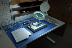 Stół techniczny, na którym znajduje się rejestrator monitoringu ze zdemontowaną częścią obudowy