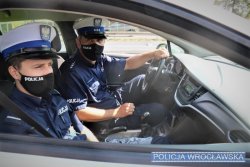 Na zdjęciu dwaj policjanci z wrocławskiej drogówki, którzy pomogli seniorowi siedzący w radiowozie