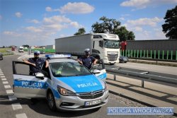 Na zdjęciu dwaj policjanci z wrocławskiej drogówki stojący radiowozem na parkingu na autostradzie A4