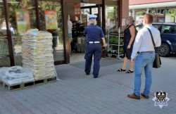 Na zdjęciu policjantka wchodzi do centrum handlowego celem kontroli, czy pracownicy oraz sami klienci stosują się do przepisów rozporządzenia Rady Ministrów w sprawie ustanowienia określonych ograniczeń, nakazów i zakazów w związku z wystąpieniem stanu epidemii w Polsce. Na zdjęciu oprócz policjantki znajduje się 3 klientów.