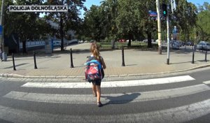 Na zdjęciu dziewczynka z plecakiem przechodząca przez oznakowane przejście dla pieszych