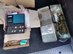 Na zdjęciu waga, amunicja i marihuana w blaszanym pojemniku.