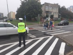 policjanci pilnują bezpieczeństwa osób przechodzących po pasach