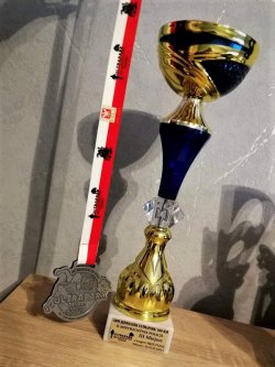 Na zdjęciu trofea: medal i puchar,  za III miejsce na podium zawodów sportowych.