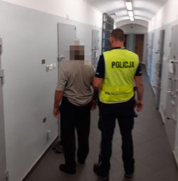 Na zdjęciu policjanci wyprowadzają zatrzymanego mężczyznę z celi pomieszczeń dla osób zatrzymanych