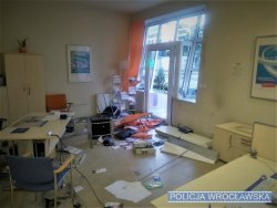Zdjęcie przedstawiające wnętrze zniszczonego biura we Wrocławiu, na którym widać porozrzucane monitory i inne przedmioty.