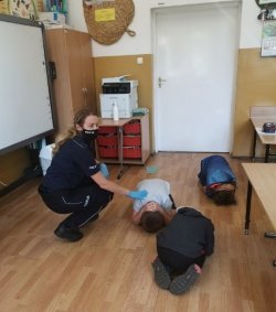 Zdjęcie przedstawia zajęcia praktyczne prowadzone przez policjantkę dla dzieci.
