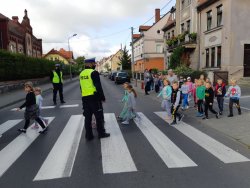 policjanci bezpiecznie przeprowadzają dzieci przez ulicę
