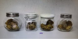 Na zdjęciu 4 słoiki z suszem marihuany i fioletową tabletką