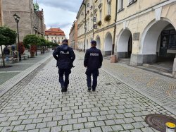 Na zdjęciu dwóch policjantów patrolujący pieszo ulice.