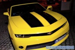 Na zdjęciu sportowy samochód marki Chevrolet koloru żółtego. Widok od przodu pojazdu.