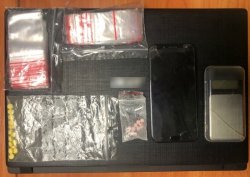 Na zdjęciu waga elektroniczna, telefon komórkowy i woreczki strunowe zabezpieczone przez policjantów w mieszkaniu 41-letniego mężczyzny