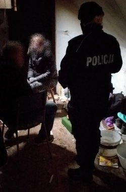 Na zdjęciu policjanci i strażnicy leśni w ramach akcji zima sprawdzają pustostany, miejsca koczowania osób w terenach leśnych. Na zdjęciu rozmawiają z bezdomnymi.