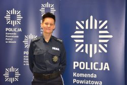 Na zdjęciu komisarz Agnieszka Borejko na tle baneru Komedy Powiatowej Policji w Oławie.