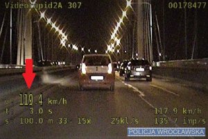 Na zdjęciu poglądowym kadr z filmu przedstawiający kierującego pojazdem przekraczającego dopuszczalną prędkość. Na rejestratorze wskazuje wartość 119,4 kilometrów na godzinę.