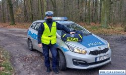 Na zdjęciu policjant aspirant sztabowy Marcin Weber, który uratował człowieka. Policjant stoi przy radiowozie.