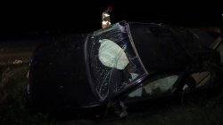 Na zdjęciu samochód osobowy po wypadku z rozbitą szybą leżący na boku.