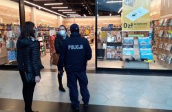 Na zdjęciu policjant wspólnie z dwiema pracownicami sanepidu kontrolują księgarnie.