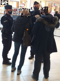 Na zdjęciu policjantka i policjant kontrolujący osoby w centrum handlowym.