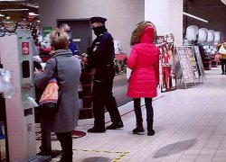 Na zdjęciu policjant w towarzystwie przedstawicielek sanepidu kontrolują centra handlowe.