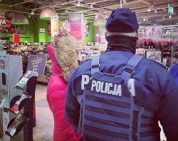 Zdjęcia przedstawia, jak policjant w towarzystwie przedstawicielki sanepidu kontrolują supermarket.